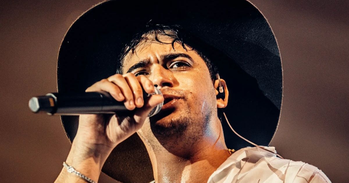 Show de Natanzinho Lima no Expo Aracruz: Cantor se apresentando no show do Natanzinho Lima em Aracruz durante a 26ª Expo Aracruz 2025, segurando microfone e usando chapéu preto