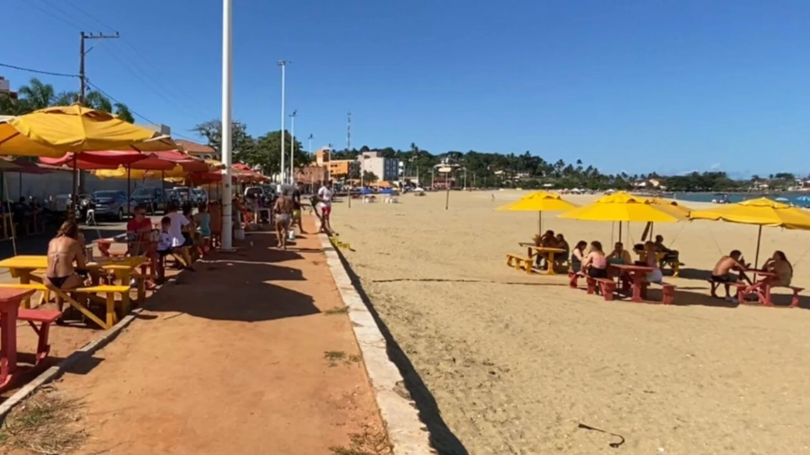 Feriados de novembro em Guarapari: Finados e Consciência Negra garantem dois fins de semana de três dias 1 Praia de Meaípe, em Guarapari, com guarda-sóis amarelos e turistas em um dia de sol