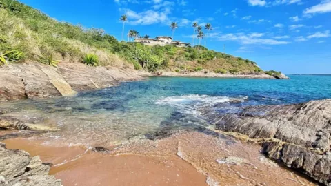 Água transparente entre pedras em praia do litoral de Guarapari