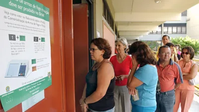 Eleitores fazem fila na porta de uma seção eleitoral para votar
